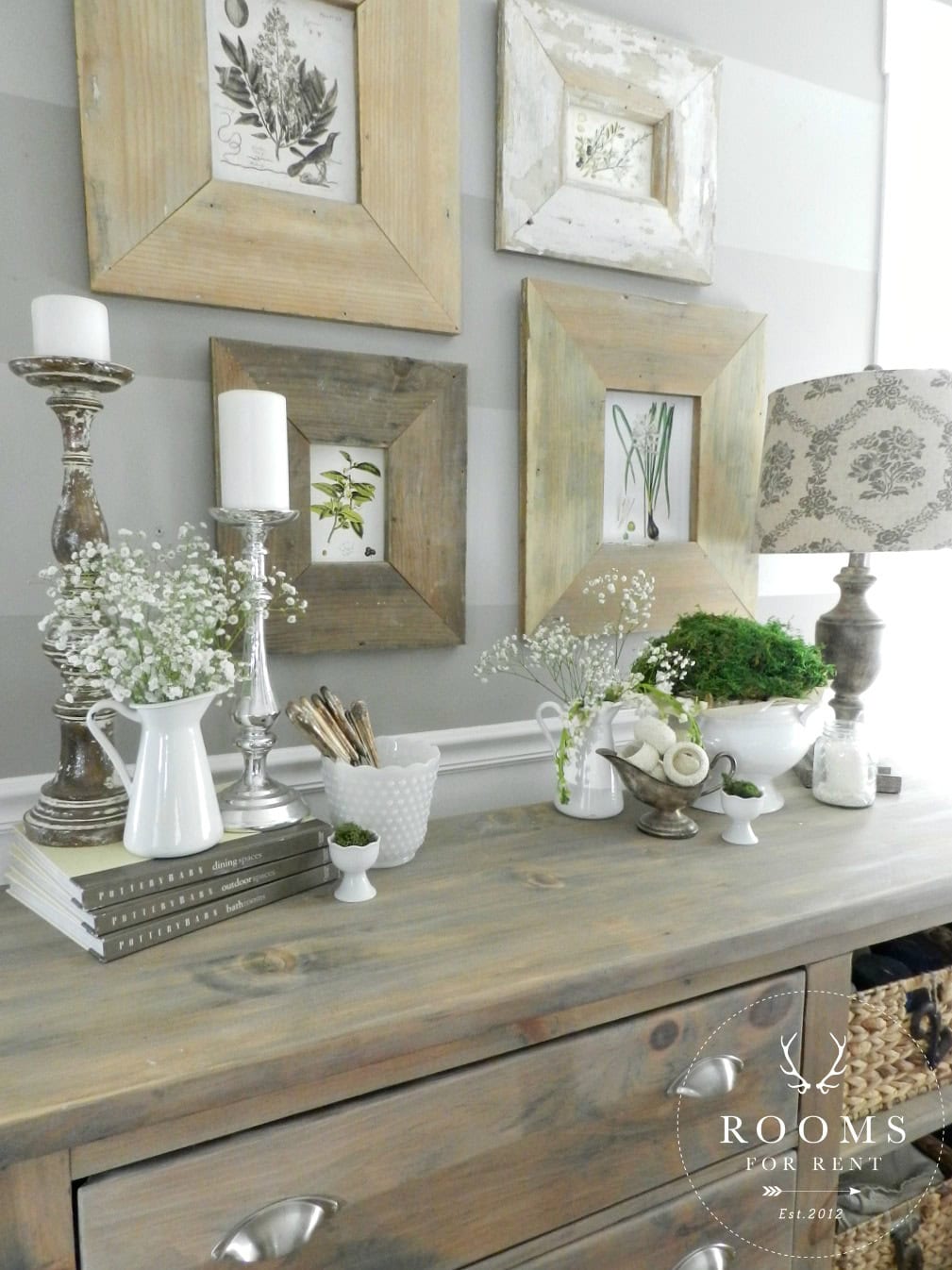 A Farmhouse Buffet table decorated with gorgeous vignettes, flowers and rustic frames on the wall