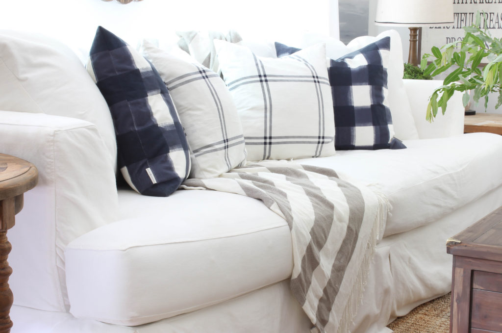 White Slipcovered sofa, with pops of blue in a relaxed, farmhouse style living room