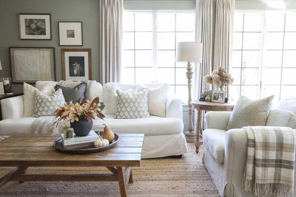 Cozy fall living room with neutral decor and white slipcovered sofas