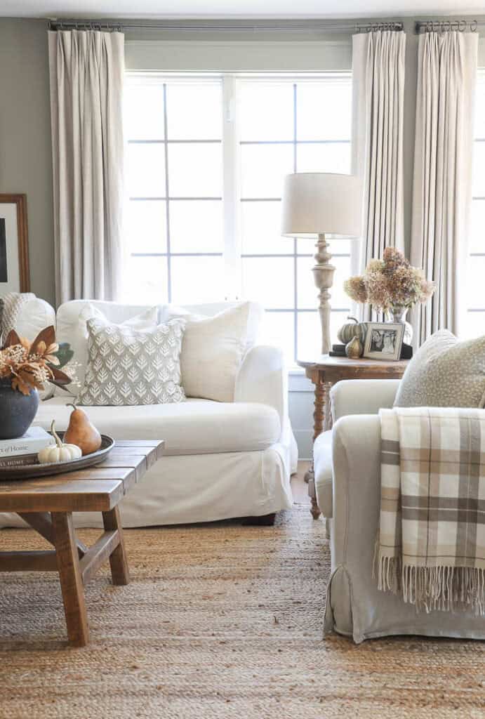 Cozy fall living room with neutral decor and white slipcovered sofas