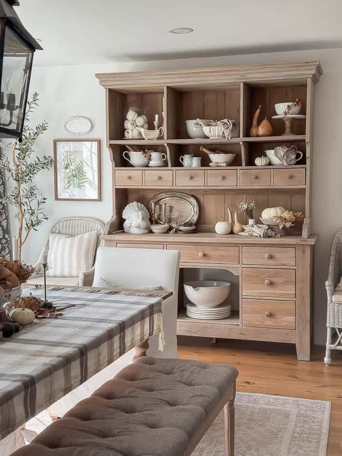 Farmhouse dining room with neutral fall table decor and wood hutch