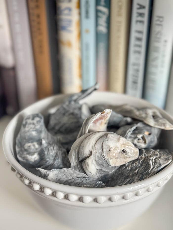 Painted hutch styled with books and seashells, traditional New England Home