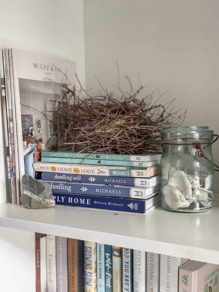 Painted hutch styled with books and seashells, traditional New England Home