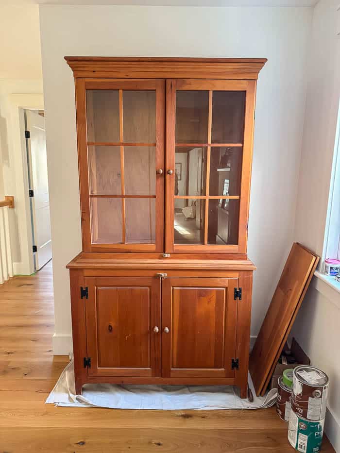 Wood hutch before makeover, original finish from Facebook Marketplace placed in an upstairs hallway prior to painting.