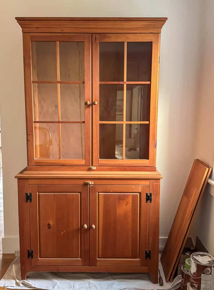 Wood hutch before makeover, original finish from Facebook Marketplace placed in an upstairs hallway prior to painting.