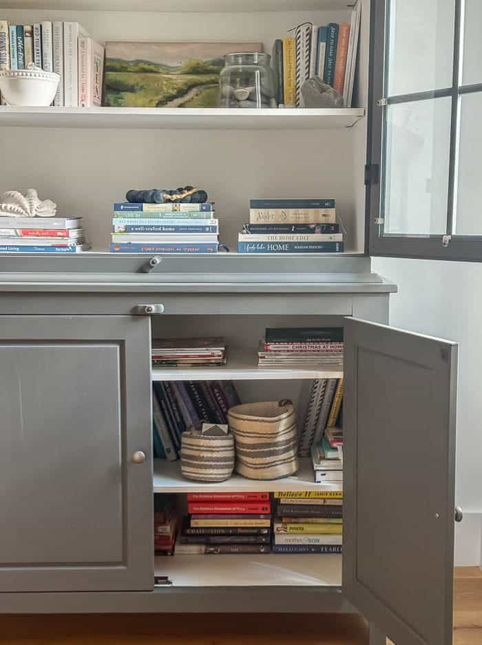 Painted hutch styled with books and seashells, traditional New England Home