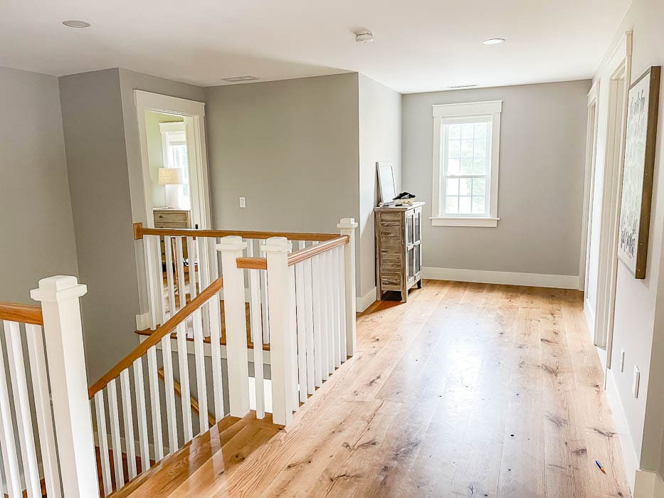 Upstairs hallway with hardwood floors and natural light, showing the scale of the space before adding a painted hutch.