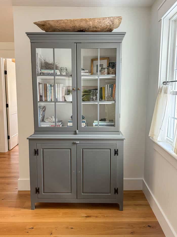 Painted hutch makeover in neutral gray, styled in a traditional New England home
