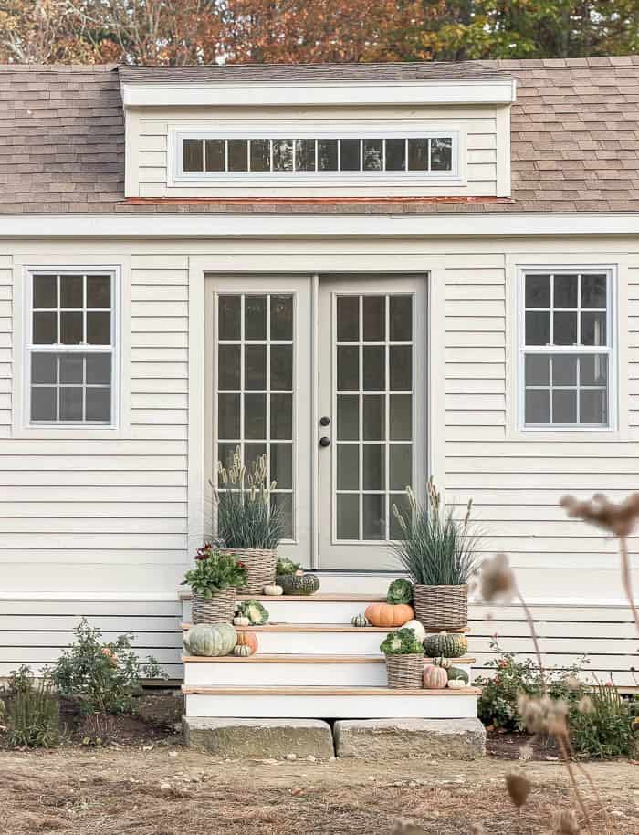 Warm gray French doors on a Pearly White garden shed
