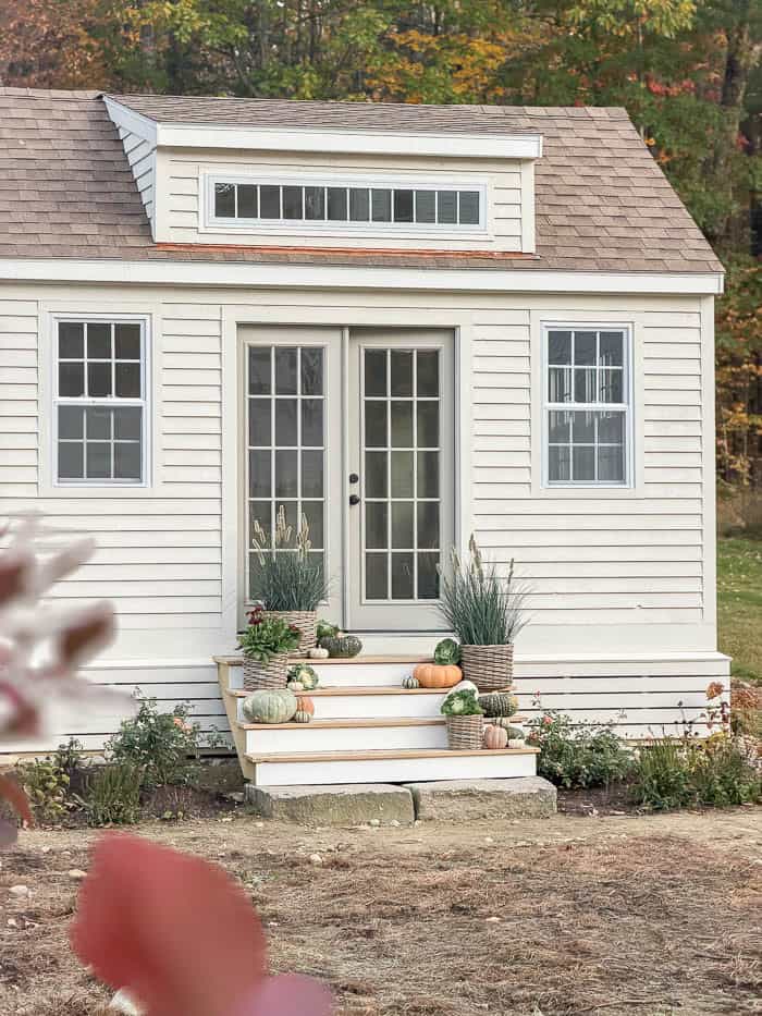 Warm gray French doors on a Pearly White garden shed